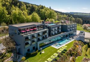 eine Luftansicht auf ein Resortgebäude mit einem Pool in der Unterkunft Hüttenhof - Wellnesshotel & Luxus-Bergchalets - Adults only in Grainet