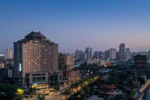 a city skyline at night with a tall building at Ji Hotel Nanchang Tengwang Pavilion in Nanchang