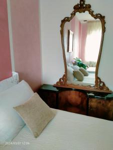 カステルヌオーヴォ・デル・ガルダにあるB&B Gardaseeのベッドルーム(鏡付きドレッサー、ベッド付)