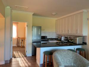 a kitchen with white cabinets and a counter top at Keurbooms River Lodge 1115 in Plettenberg Bay