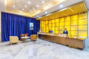 a lobby with two people at a reception desk at Starway Hotel Xining Chengbei Wanda Plaza in Xining