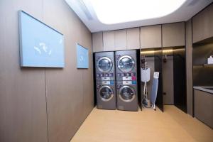 um quarto com duas máquinas de lavar roupa e uma televisão em Ji Hotel Jinan East Railway Station em Licheng