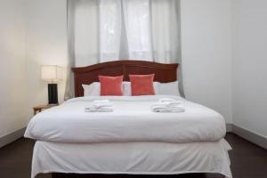 a bedroom with a large white bed with red pillows at East Lake Update-Close to Dining, 10min to Airport in Birmingham