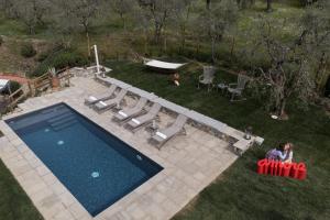 uma vista superior para uma piscina com cadeiras e uma mesa em Villa Alma - Homelike Villas em Montelupo Fiorentino