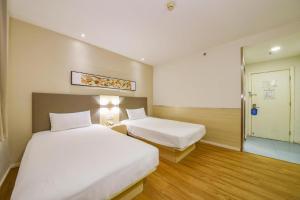 Hanting Hotel Jinan Jing'er Road Railway Station tesisinde bir odada yatak veya yataklar