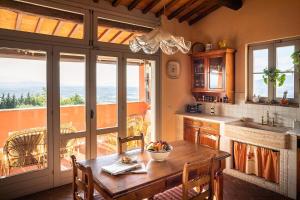 uma cozinha com uma mesa de madeira com cadeiras e uma janela em Villa Alma - Homelike Villas em Montelupo Fiorentino