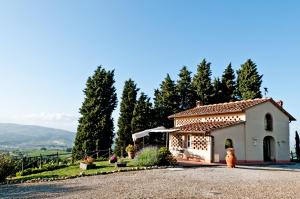 un pequeño edificio blanco con árboles en el fondo en Villa Mea - Homelike Villas, en Montelupo Fiorentino