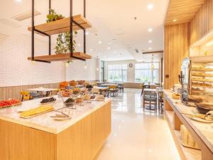a large kitchen with a counter with food on it at Hanting Premium Hotel Qingdao Ocean University of China in Kutao