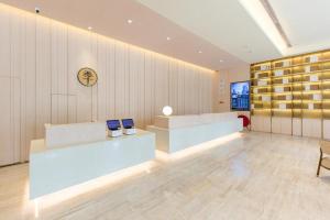 a lobby with two desks and a clock on the wall at Ji Hotel Quanzhou Jinjiang International Airport in Jinjiang