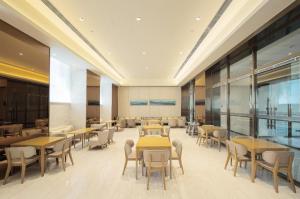 una sala da pranzo con tavoli e sedie in un edificio di Ji Hotel Jilin Wanda Plaza a Jilin