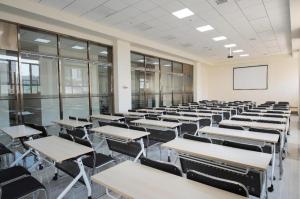 uma sala de aula vazia com mesas e cadeiras em Ji Hotel Jilin Wanda Plaza em Jilin