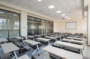 uma sala de aula vazia com fileiras de mesas e cadeiras em Ji Hotel Jilin Wanda Plaza em Jilin