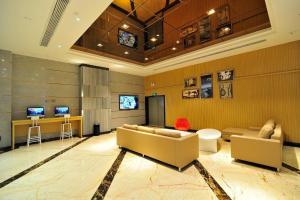 a living room with two couches and a television at Starway Hotel Guiyang Big Cross in Guiyang