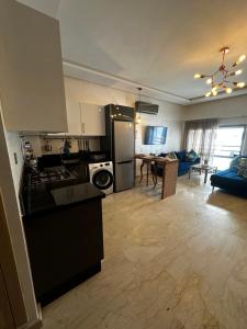 una cucina e un soggiorno con piano cottura e frigorifero di Appartement confortable et pas cher au parc a Mohammedia