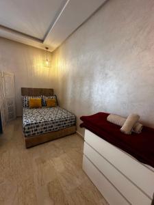 Habitación pequeña con cama y sofá en Appartement confortable et pas cher au parc en Mohammedia