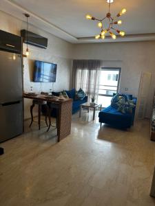 un soggiorno con divano blu e tavolo di Appartement confortable et pas cher au parc a Mohammedia