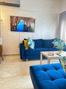 un soggiorno con divano blu e tavolo di Appartement confortable et pas cher au parc a Mohammedia