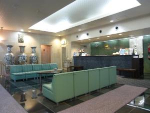 a waiting room with green chairs and a counter at Minami Fukuoka Green Hotel in Fukuoka
