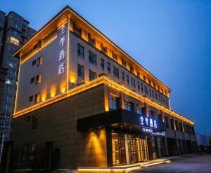 un edificio con luces en el lateral. en JI Hotel Kaifeng Qingming Shanghe Garden Fuxing Avenue, en Kaifeng