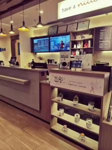 a coffee shop with a counter with cups on shelves at Hanting Hotel Heze Dingtao in Youji