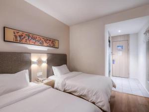 a hotel room with two beds and a bathroom at Hanting Hotel Nanjing Yaohuamen in Qianjiadu