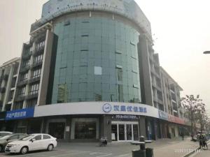 DonghaiにあるHanting Premium Hotel Donghai County Governmentの車が目の前に停まった大きな建物