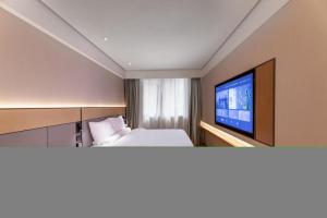pokój hotelowy z łóżkiem i telewizorem z płaskim ekranem w obiekcie Ji Hotel Suzhou Guanqian Street Ganjiang Xi Road w mieście Suzhou