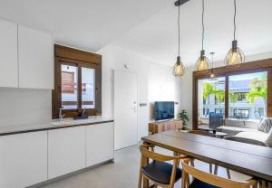 een keuken en eetkamer met witte kasten en een tafel bij Apartment Los Balcones - Torrevieja in Torrevieja