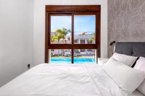 een slaapkamer met een wit bed en een raam bij Apartment Los Balcones - Torrevieja in Torrevieja