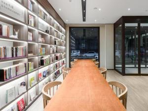 a long conference room with a long table and bookshelves at Hanting Hotel Xi'An Zhouzhi Water Street in Zhouzhi