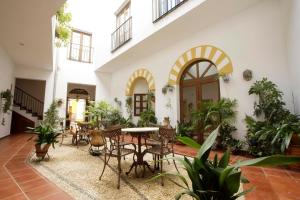un patio con mesas, sillas y plantas en Hotel San Miguel, en Córdoba