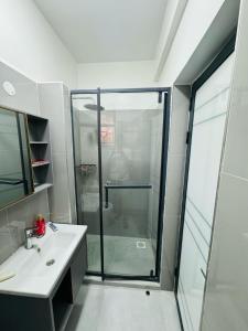 y baño con ducha acristalada y lavamanos. en Azania Homes 2bedrooms Apartments Westlands, en Nairobi