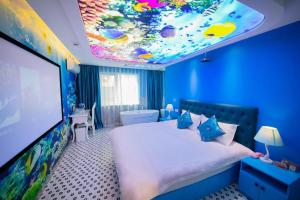 a blue room with a large bed with a large screen at Hi Inn Nanjing Hunan Road Wuyue Plaza in Nanjing