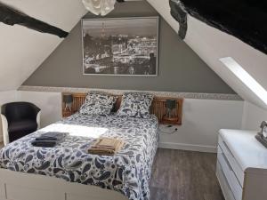 1 dormitorio con 1 cama con edredón blanco y negro en Gîte L'Escale Charmante en Choussy