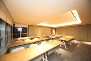 a conference room with wooden tables and white chairs at Ji Hotel Suqian Wanda Plaza in Suqian