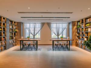a room with two tables and chairs in a library at Hanting Hotel Taiyuan Qianfeng South Road in Xiayuan