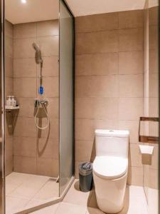a bathroom with a shower with a toilet and a glass shower at Hanting Hotel Taiyuan Qianfeng South Road in Xiayuan