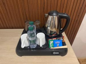 a tray with water bottles and a tea kettle on a table at شقق روز الفندقية دخول ذاتي in Al Khobar