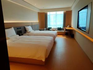 Cette chambre comprend 2 lits et une fenêtre. dans l'établissement Ji Hotel Zunyi Xishui, à Xishui