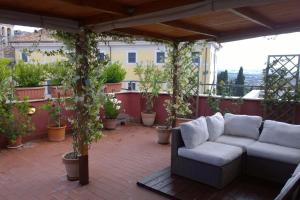 a patio with a couch and some potted plants at Il Tramonto su Tivoli in Tivoli