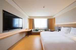 Habitación de hotel con cama grande y TV de pantalla plana. en Ji Hotel Linfen Gulou South Street, en Linfen