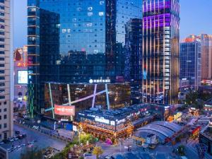 uitzicht op een stad in de nacht met hoge gebouwen bij Hanting Premium Hotel Xining Tangdao Wanda Plaza in Xining