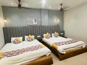 two beds in a hotel room with two at HOTEL DEVA INN in Varanasi