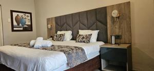 a bedroom with two beds and a large headboard at Luxe Florida Grand Hotel in Durban +19 photos