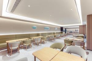 a cafeteria with tables and chairs in a room at Ji Hotel Wenzhou Feixia South Road in Wenzhou