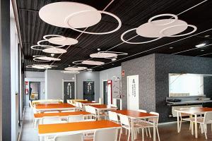 une salle à manger avec des tables et des chaises blanches dans l'établissement Mola! Hostel Burgos, à Burgos