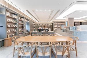 - une salle à manger avec une table et des chaises en bois dans l'établissement Ji Hotel Guiyang Guanshan Lake High-Tech Zone, à Jinzhuzhen