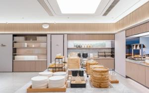 uma cozinha com pratos brancos em exposição num restaurante em Ji Hotel Guiyang Guanshan Lake High-Tech Zone em Jinzhuzhen