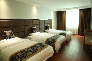 um quarto de hotel com três camas e uma janela em Elan Boutique Hotel Wenzhou Longwan Haicheng em Ch'a-shan-chieh