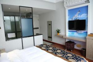 1 dormitorio con 1 cama y ventana grande con TV en Elan Boutique Hotel Wenzhou Longwan Haicheng, en Ch'a-shan-chieh